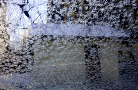 A house is seen through the glass covered with ice crystals in Moscow, capital of Russia, Dec. 18, 2009.(Xinhua/Lu Jinbo)