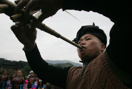 A man of the Miao ethnic group plays the reed flute in Rongshui Miao Autonomous County of southwest China's Guangxi Zhuang Autonomous Region, Dec. 17, 2009, as the Miao people welcome their new year according to their own calendar. People of different ethnic groups in the surrounding areas gathered in Liujin Village of Rongshui County to observe the festival with Lusheng dances, folk songs, etc. from Thursday. The observing activities will last for over ten days successively in different villages. (Xinhua/Wang Zhongkang)