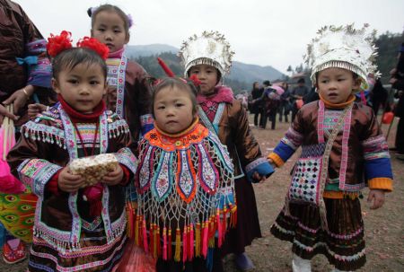 Girls of the Miao ethnic group attend new year observing activities in festive costumes in Rongshui Miao Autonomous County of southwest China's Guangxi Zhuang Autonomous Region, Dec. 17, 2009.(Xinhua/Wang Zhongkang)