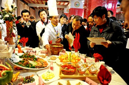 A cuisine chef introduces his works to judges at the 2009 Guiyang Contest of Cuisine for Tourism in Guiyang, southwest China's Guizhou Province, Dec. 18, 2009. The two-day contest, which was kicked off on Friday, had attracted chefs from about 50 restaurants to show their skills. (Xinhua/Liu Hui)