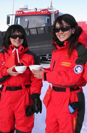 Two female members of China's expedition team drink before their journey in Zhongshan station, Antarctica, December 18, 2009.