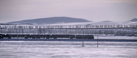 A train runs along the railway surrounded by snow-covered land in north China's Inner Mongolia Autonomous Region, December 19, 2009. A cold snap coming from Siberia swept easter part of Inner Mongolia on Friday and Saturday. The cold snap brought sharp drop of temperatures in the autonomous region where the lowest temperatures fell to about minus 30 degrees Celsius.