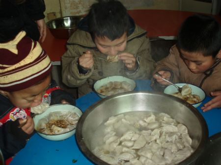 Disabled children enjoy the dinner of dumplings, or jiaozi in Chinese, at Xi'an Xinxin Kindergarten in Xi'an, capital of northwest China's Shaanxi Province, December 19, 2009. With the advent of winter solstice, over 30 volunteers came to Xi'an Xinxin Kindergarten on Saturday and made dumplings with the disabled children there. 