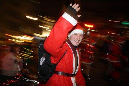 A roller skater dressed as Santa Clause gives a tourist a hug during the Santa Skate at Trafalgar Square in London, capital of Britain, on December 19, 2009. 