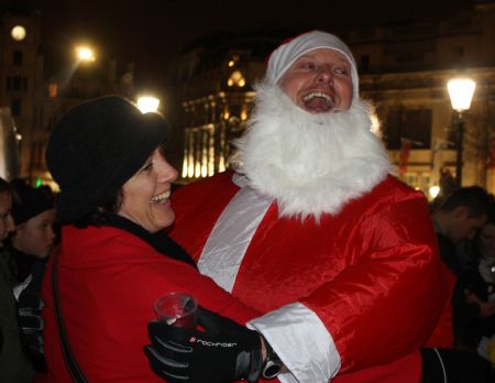 A roller skater dressed as Santa Clause gives a tourist a hug during the Santa Skate at Trafalgar Square in London, capital of Britain, on December 19, 2009. 