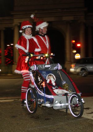  A couple of roller skaters dressed as Santa Clause push a baby carriage as they skate along the streets during the Santa Skate in London, capital of Britain, on December 19, 2009. 
