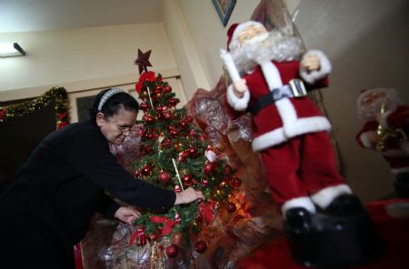 Soad al-Massri, 57-year-old Palestinian Christian, decorates Christmas tree at her house in Gaza City December 22, 2009. 