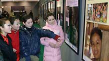 People look at pictures during the 2009 Universal Children's Day photo exhibition in Hohhot, capital city of north China's Inner Mongolia Autonomous Region, December 22, 2009.