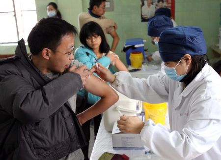 Students of Fudan University are injected with the vaccine against the A/H1N1 flu in Shanghai, east China, on December 23, 2009. The vaccination campaign against the A/H1N1 flu virus was launched in late November among colleges and universities in Shanghai. Some 37 percent of 640,000 students and teachers here have already consented to receive the vaccine injections.