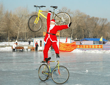 Zhou Changchun dressed as Santa Claus performs bike stunt in Changchun, capital of northeast China's Jilin Province, December 23, 2009.