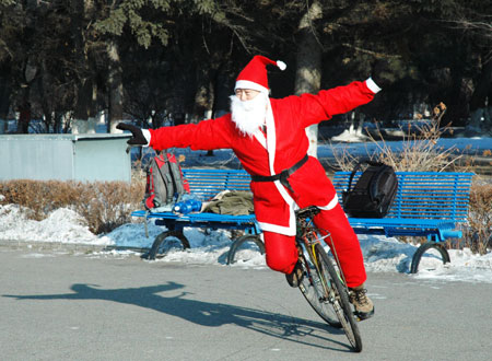 Zhou Changchun dressed as Santa Claus performs bike stunt in Changchun, capital of northeast China's Jilin Province, December 23, 2009.