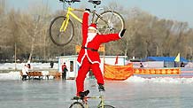 Zhou Changchun dressed as Santa Claus performs bike stunt in Changchun, capital of northeast China's Jilin Province, December 23, 2009.