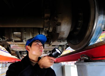 A worker checks a high-speed train at the high-speed railway maintenance base in Wuhan, capital of central China's Hubei Province, December 22, 2009.