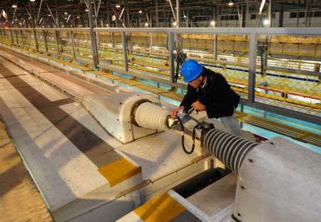 A worker checks on the top of a high-speed train at the high-speed railway maintenance base in Wuhan, capital of central China's Hubei Province, December 22, 2009.