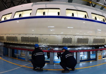 Workers check a high-speed train at the high-speed railway maintenance base in Wuhan, capital of central China&apos;s Hubei Province, December 22, 2009. 