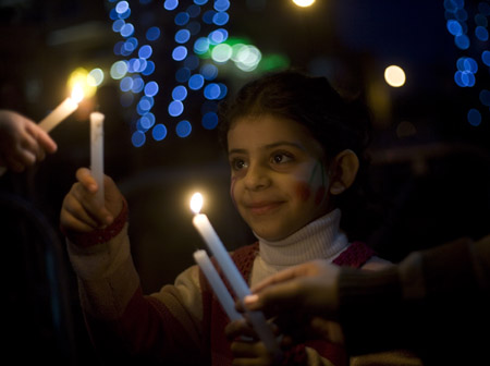 A Palestinian girl takes part in a candle-lighting protest in solidarity with Gaza, in the West Bank city of Ramallah, on December 27, 2009. Palestinians on Sunday held a protest against the Israeli offensive on Gaza Strip which killed more than 1,400 Palestinians on December 27, 2008. December 27, 2009 is the first anniversary of the Israeli offensive on Gaza Strip.