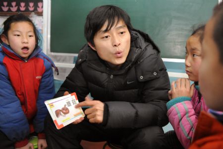  A teacher talks to students with special difficulties on speaking at a special education school in Shenmu County, northwest China's Shaanxi Province, December 23, 2009. 