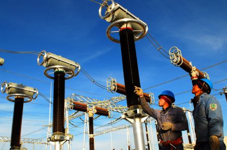 Workers debug the equipment at the wind power base in Jiuquan City, northwest China's Gansu Province, December 8, 2009. 
