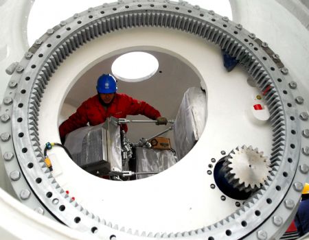 A worker checks the circuit of a wind machine in the wind power base in Jiuquan City, northwest China's Gansu Province, December 7, 2009. 