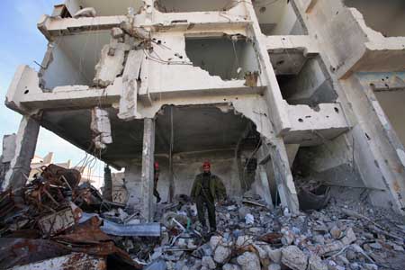 A member of Hamas security forces walks over the rubble of their main compound destroyed during the Israel's military operation one year ago, in Gaza City, December 28, 2009. 