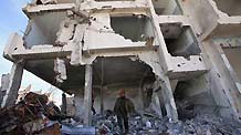 A member of Hamas security forces walks over the rubble of their main compound destroyed during the Israel's military operation one year ago, in Gaza City, December 28, 2009.