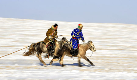Herdsmen of Mongolian ethnic group preform equestrian skills in Xi Ujimqin Qi, north China's Inner Mongolia Autonomous Region, on December 28, 2009. 