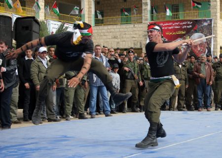 Palestinian policemen take part in a parade to celebrate the 50th Anniversary of the founding of the Fatah movement in the West Bank city of Jenin, on December 29, 2009.