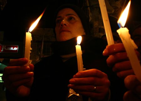 Palestinians hold candles to mark the one-year anniversary of Israeli offensive on the Gaza Strip, in the West Bank city of Nablus, on January 2, 2010. 