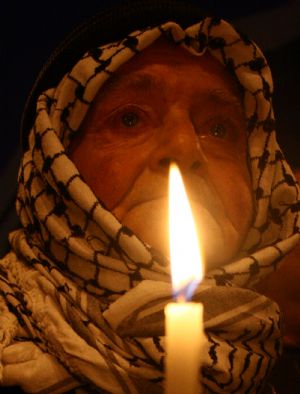 A Palestinian holds a candle to mark the one-year anniversary of Israeli offensive on the Gaza Strip, in the West Bank city of Nablus, on January 2, 2010.