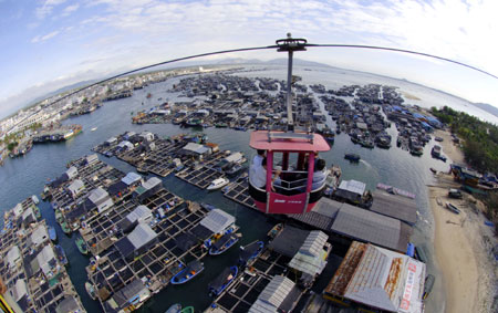 A cable car is seen against the backdrop of the seascape in Hainan Province on December, 2009.