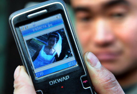 Tao Huajiang displays a photo of his late wife Yang Cuicui who died from A/H1N1 flu six days after giving birth to three baby girls via cesarean section, at Magezhuang village in Pingdu City, east China's Shandong Province January 6, 2010.