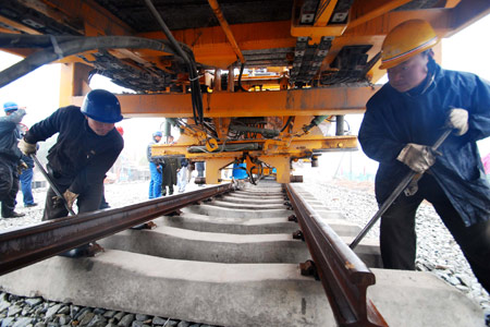 Workers at the Lushan station in Jiangxi Province lay tracks for the express rail running between provincial capital Nanchang and Jiujiang on Monday. The line is China's second inter-city express rail after the Beijing-Tianjin link. 