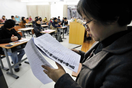 An examiner checks the candidates&apos; information at an exam room in Guangdong University of Foreign Studies in Guangzhou, capital of south China&apos;s Guangdong Province, on January 9, 2010.