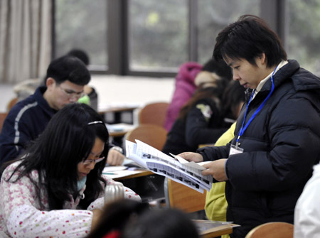 An examiner checks the candidates&apos; information at an exam room at Guangdong University of Foreign Studies in Guangzhou, capital of south China&apos;s Guangdong Province, on January 9, 2010.