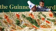 A chef helps a boy to taste the world's biggest hummus in Abu Gosh, an Arab village about 10 kilometers west of Jerusalem, on January 8, 2010.