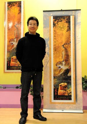 Canadian Chinese Wilson Lam poses for photos with a sample of the tiger stamp designed by him during a reception to celebrate Canada Post's issuing a set of Year of the Tiger stamps to mark the upcoming Chinese lunar new year in Ottawa, Canada, January 8, 2010.