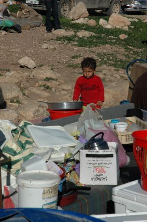 A Palestinian boy stands next his family belongings after the Israeli bulldozers destroyed her house in the village of Tana, in the West Bank city of Nablus, January 10, 2010. 