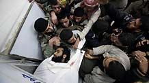 Palestinians mourn over the body of a Gaza militant killed in an Israeli missile strike, in the central Gaza town of Deir al-Balah, January 10, 2010.