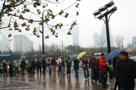 People queue up in the rain for tickets for the American science fiction movie 'Avatar' at the Heping Cinema in downtown Shanghai, China, January 10, 2010. 