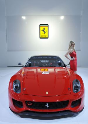 A model presents a Ferrari sports car during the press preview of the 2010 North American International Auto Show (NAIAS) at Cobo center in Detroit, Michigan, the United States, January 11, 2010. 