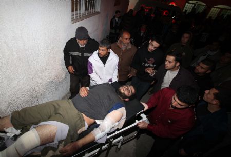 Palestinians carry the wounded at Kamal Adwan Hospital after an Israeli air strike in Beit Hanoun, northern Gaza Strip January 11, 2010.