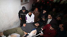 Palestinians carry the wounded at Kamal Adwan Hospital after an Israeli air strike in Beit Hanoun, northern Gaza Strip January 11, 2010.