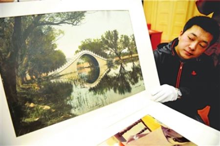 The staff shows the donation of the hand coloring old photo of Yudai Qiao (Jade Belt Bridge).