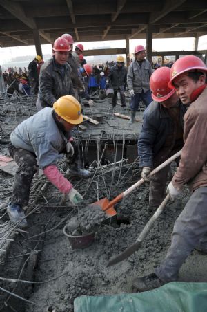 RRescue workers implement urgent aid to those trapped in a scaffold-collpase accident at a construction site in Wuhu City, east China's Anhui Province, January 12, 2010.