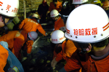 Rescuers work at the scene of a collapse accident at the construction site of Wuhu Huaqiang Culture and Technology Park in Wuhu, east China's Anhui Province, January 12, 2010.