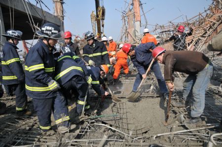 Rescue workers implement urgent aid to those trapped in a scaffold-collpase accident at a construction site in Wuhu City, east China's Anhui Province, January 12, 2010.