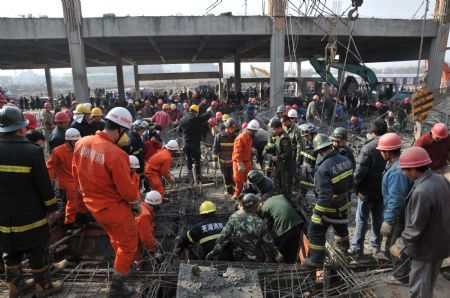 Rescue workers implement urgent aid to those trapped in a scaffold-collpase accident at a construction site in Wuhu City, east China's Anhui Province, January 12, 2010.