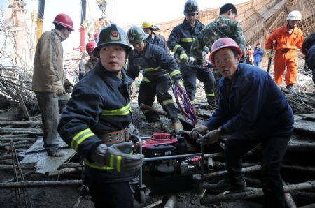 Rescue workers implement urgent aid to those trapped in a scaffold-collpase accident at a construction site in Wuhu City, east China's Anhui Province, January 12, 2010.