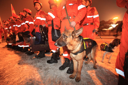 Members of a Chinese rescue team with sniffer dogs board a plane leaving for quake-hit Haiti, at the Capital International Airport in Beijing, capital of China, January 13, 2010.