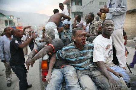 Injured people are transferred for treatment after a powerful earthquake on a street of Haiti's capital Port-au-Prince on January 12, 2010. 